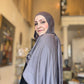 Woman wearing a gray hijab in an indoor setting