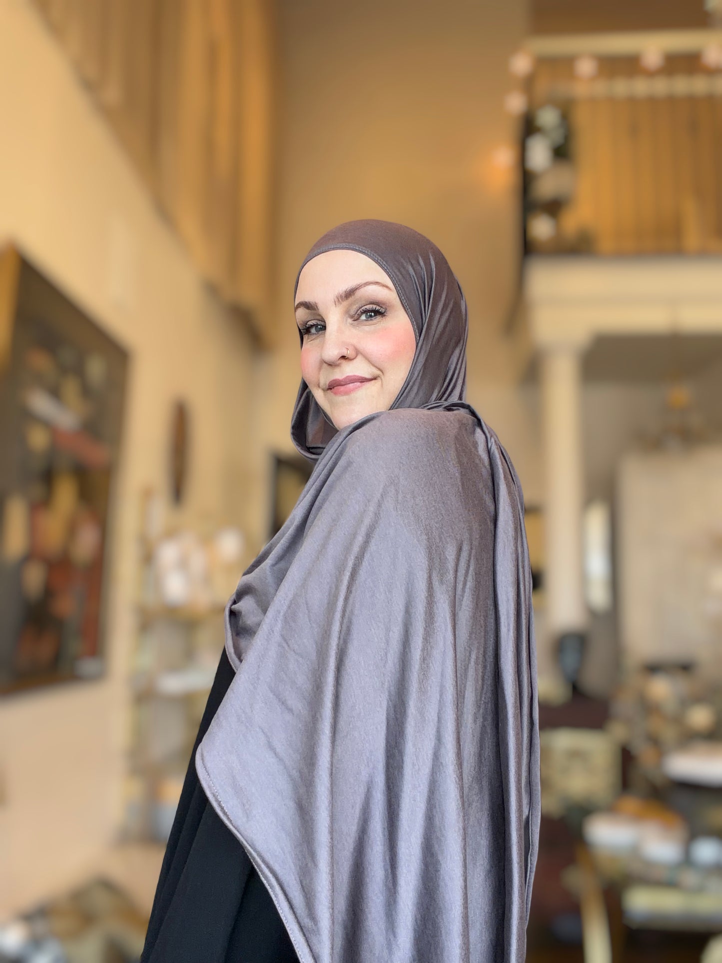 Woman wearing a gray hijab in an indoor setting